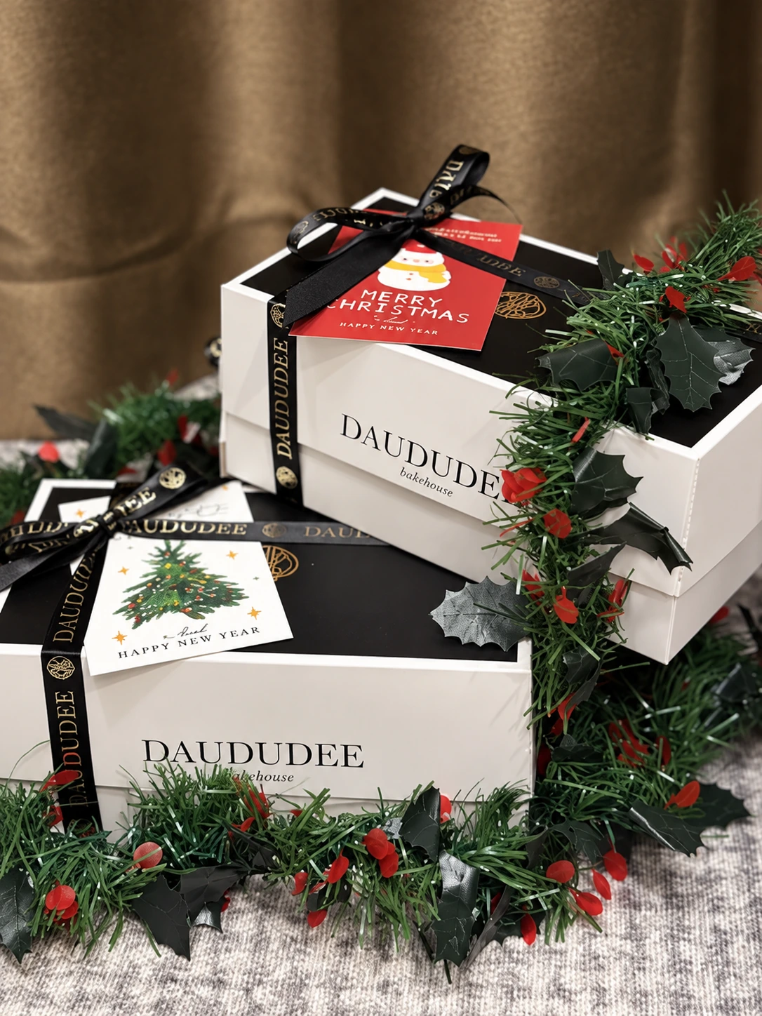Christmas gift boxes with black ribbon and festive greeting cards