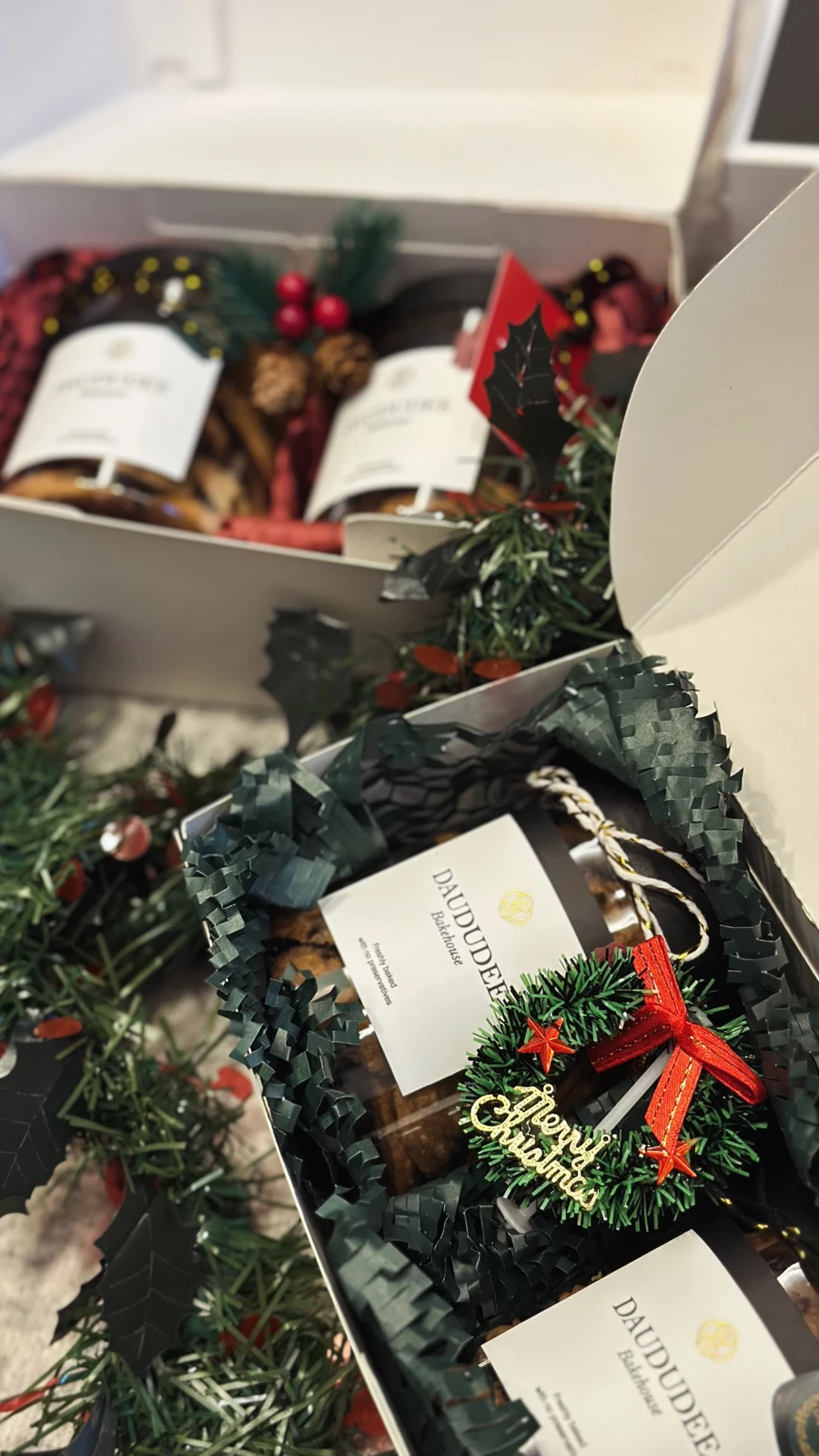 Christmas cookie gift boxes with green paper and festive wreath decoration