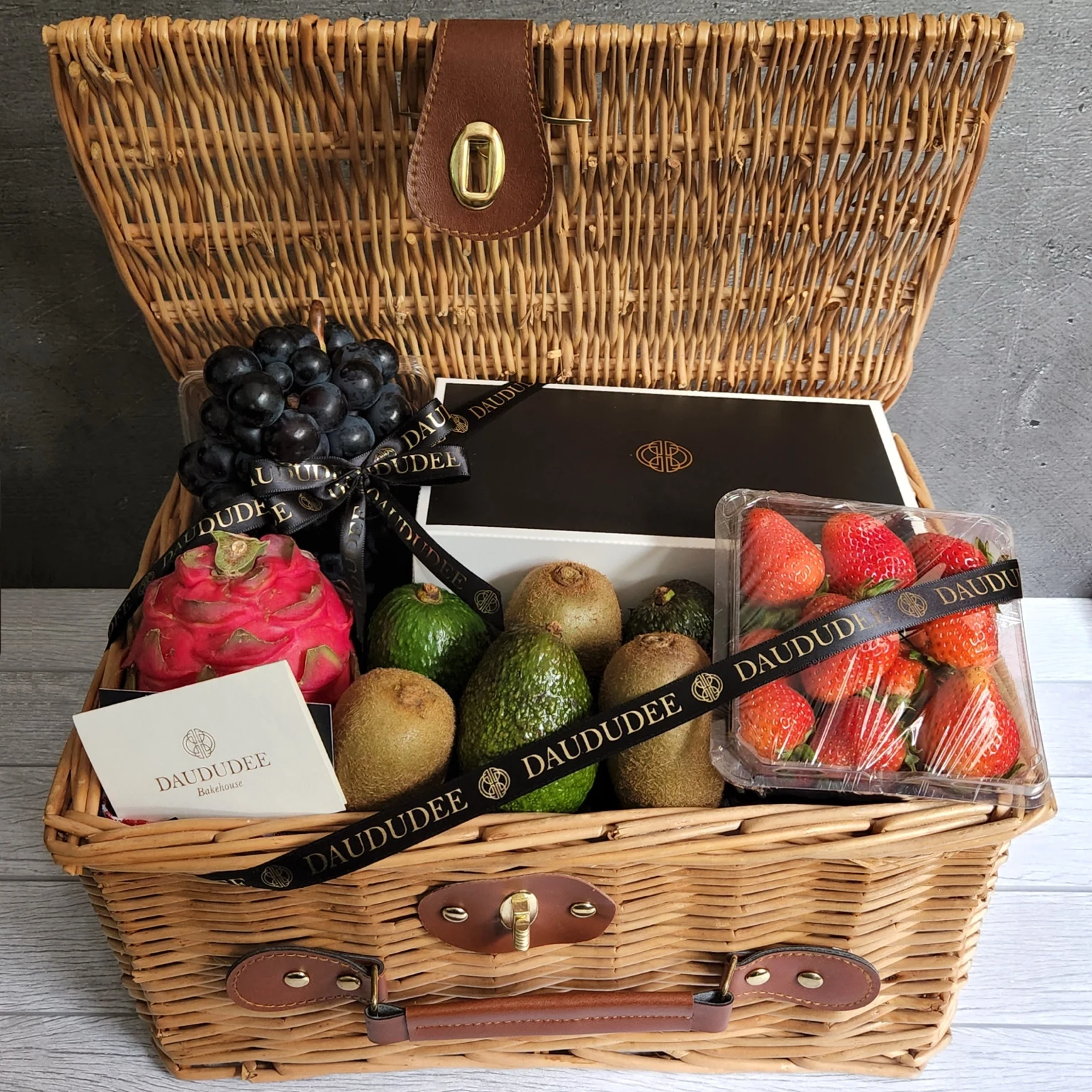 Wicker fruit hamper with dragon fruit, grapes, avocados, kiwis and strawberries