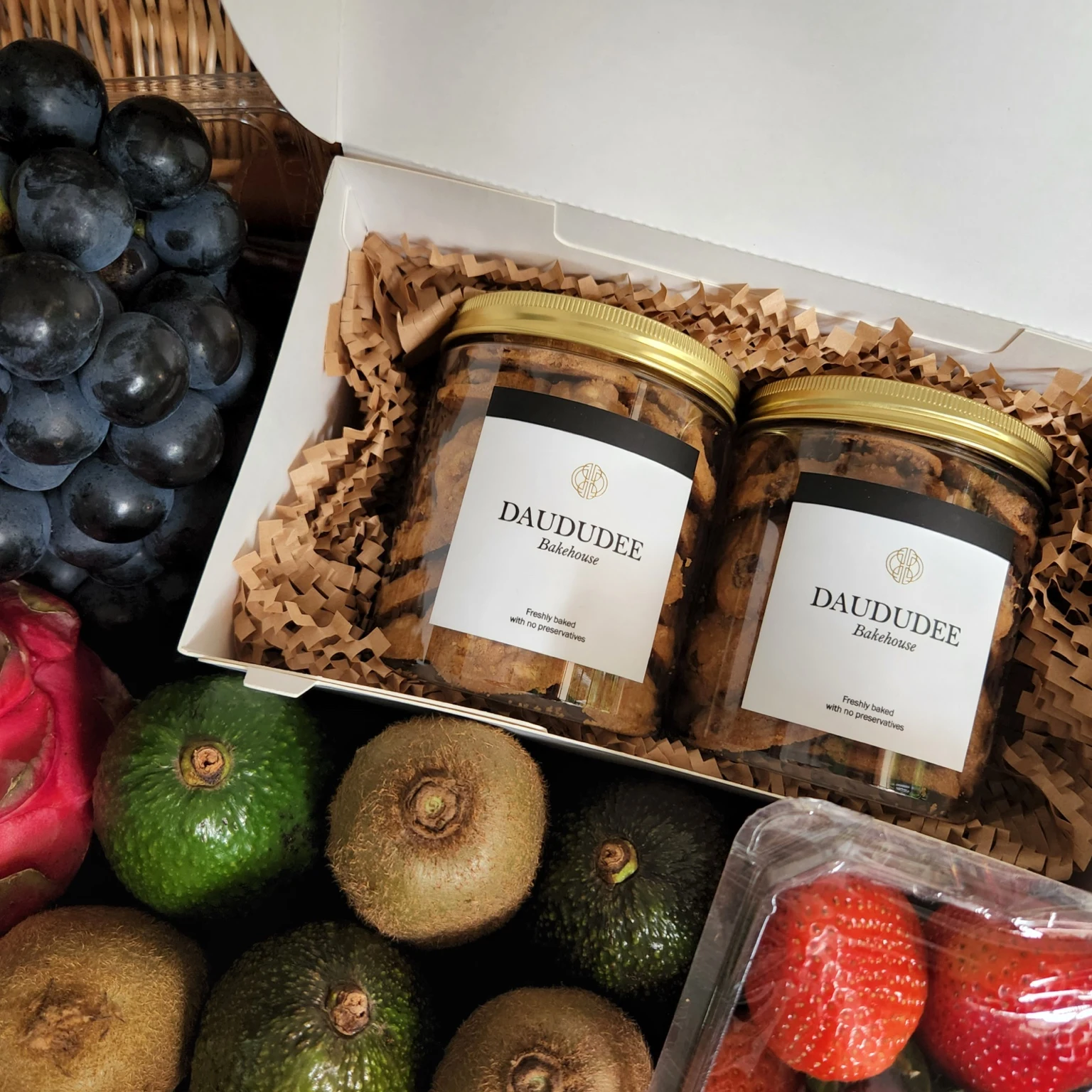 Two-jar cookie gift box alongside fresh fruit