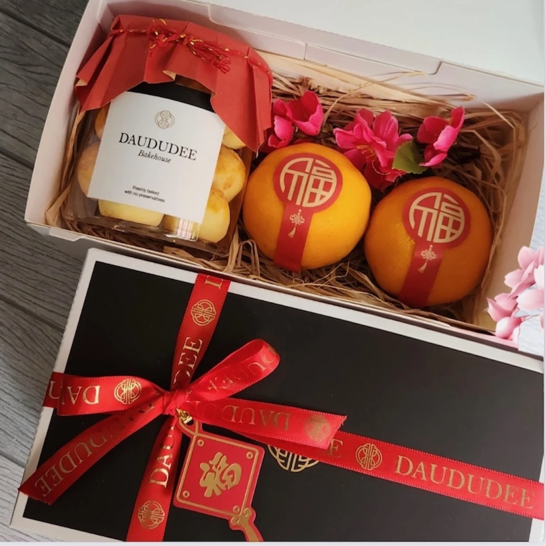 Pineapple tarts and two mandarins in a festive gift box