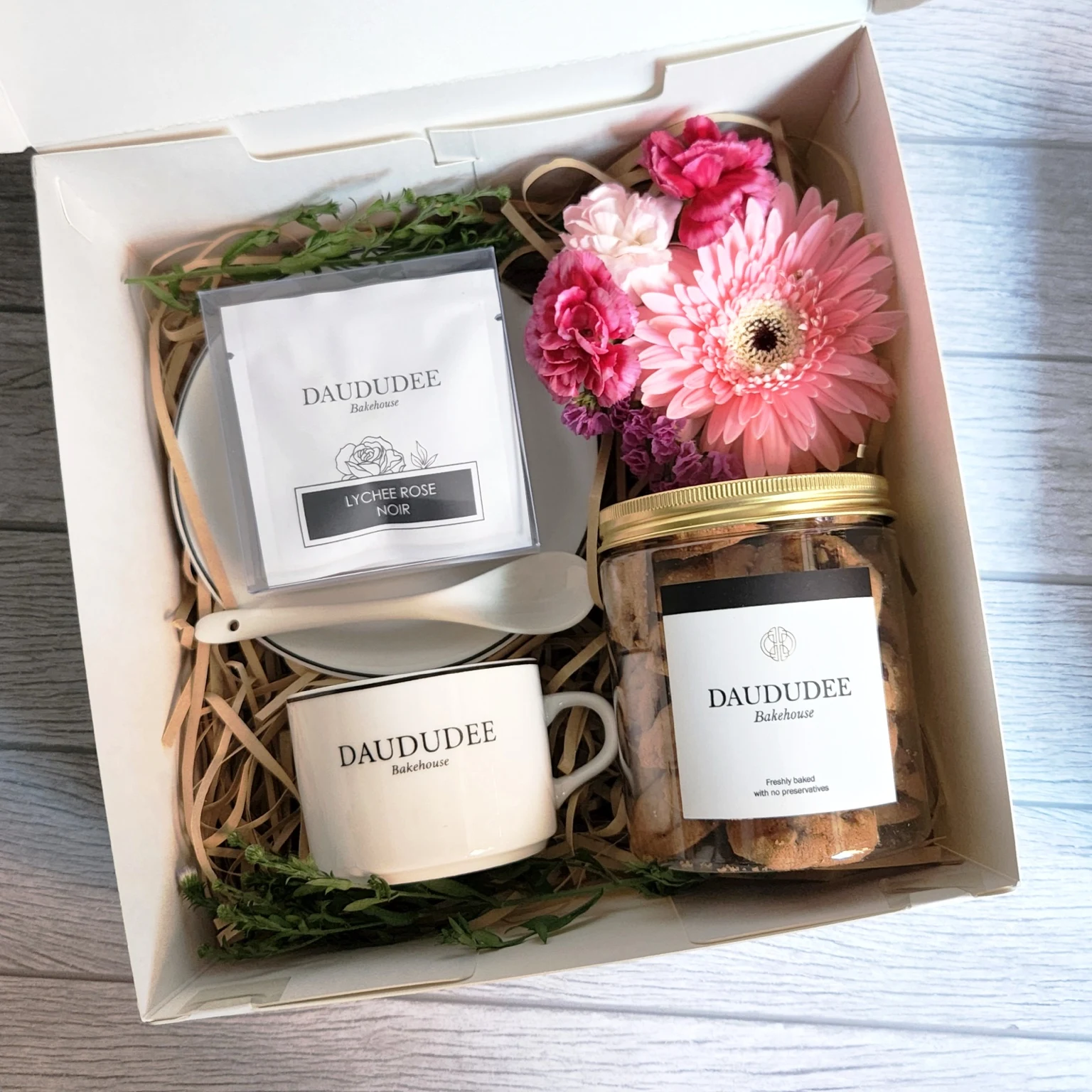 Mother’s Day gift box with teacup, tea, cookies and pink flowers