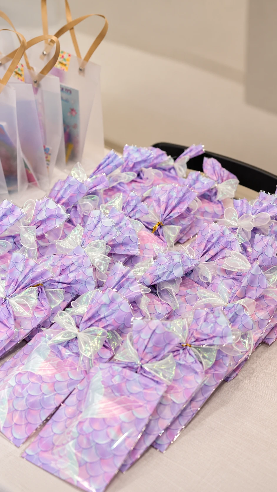 Pastel mermaid-scale party packs tied with iridescent bows