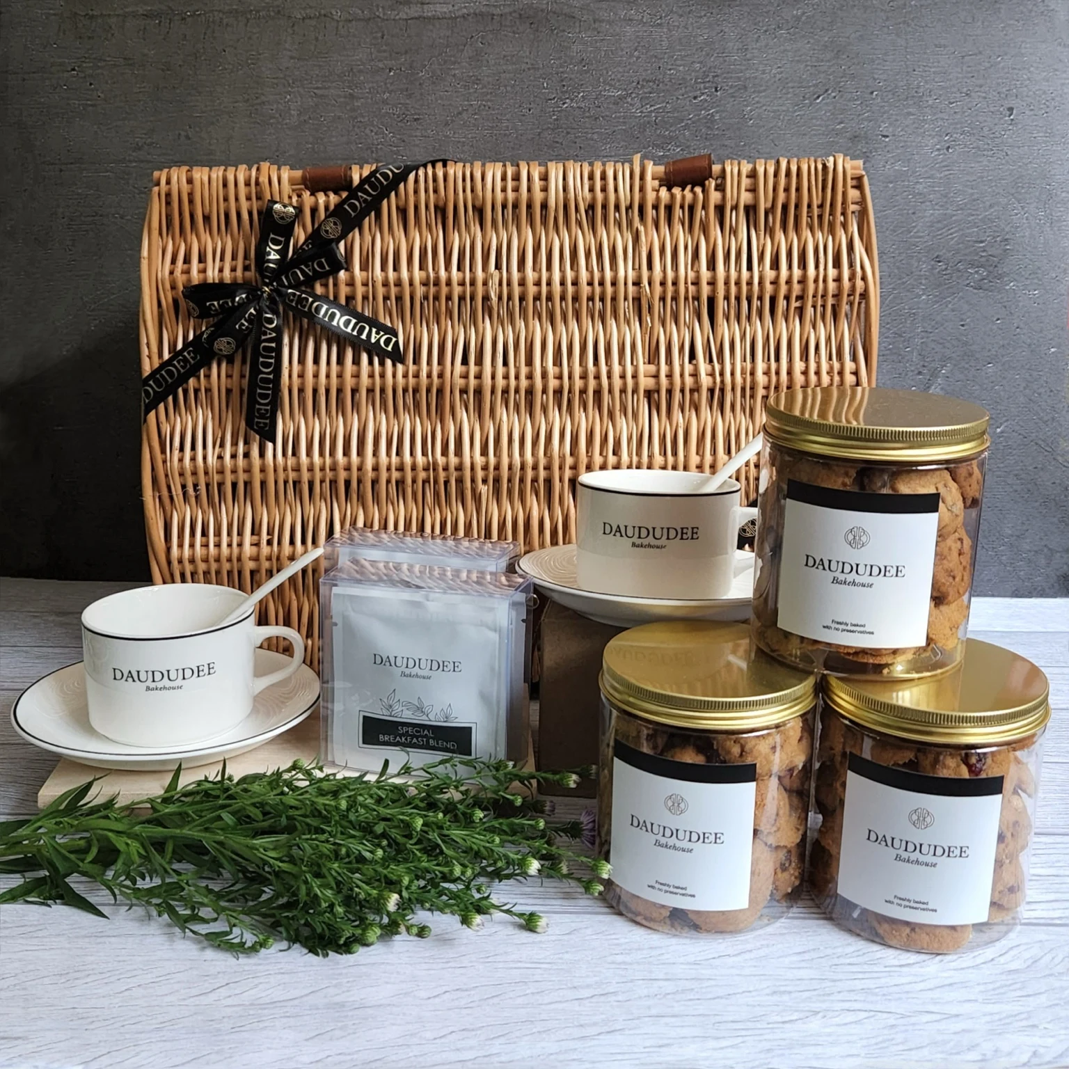 Picnic basket with two teacups, tea and three cookie jars